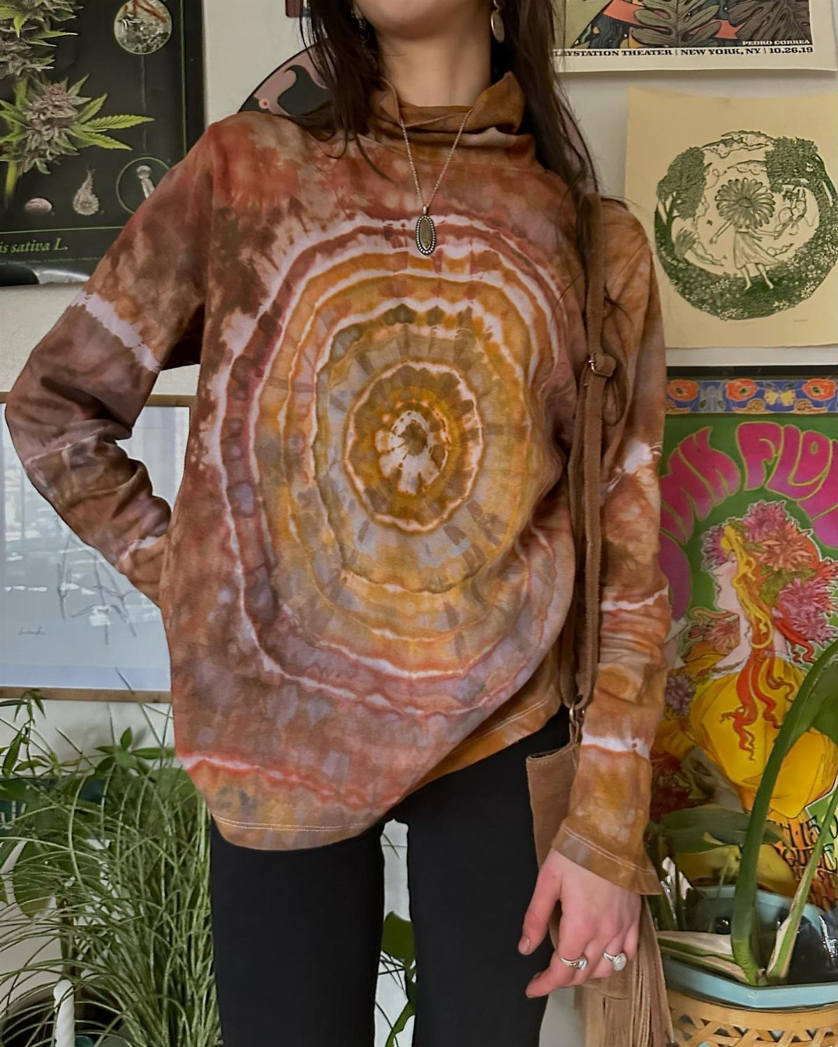 A person wearing a brown and orange concentric circle tie-dye long-sleeved shirt.