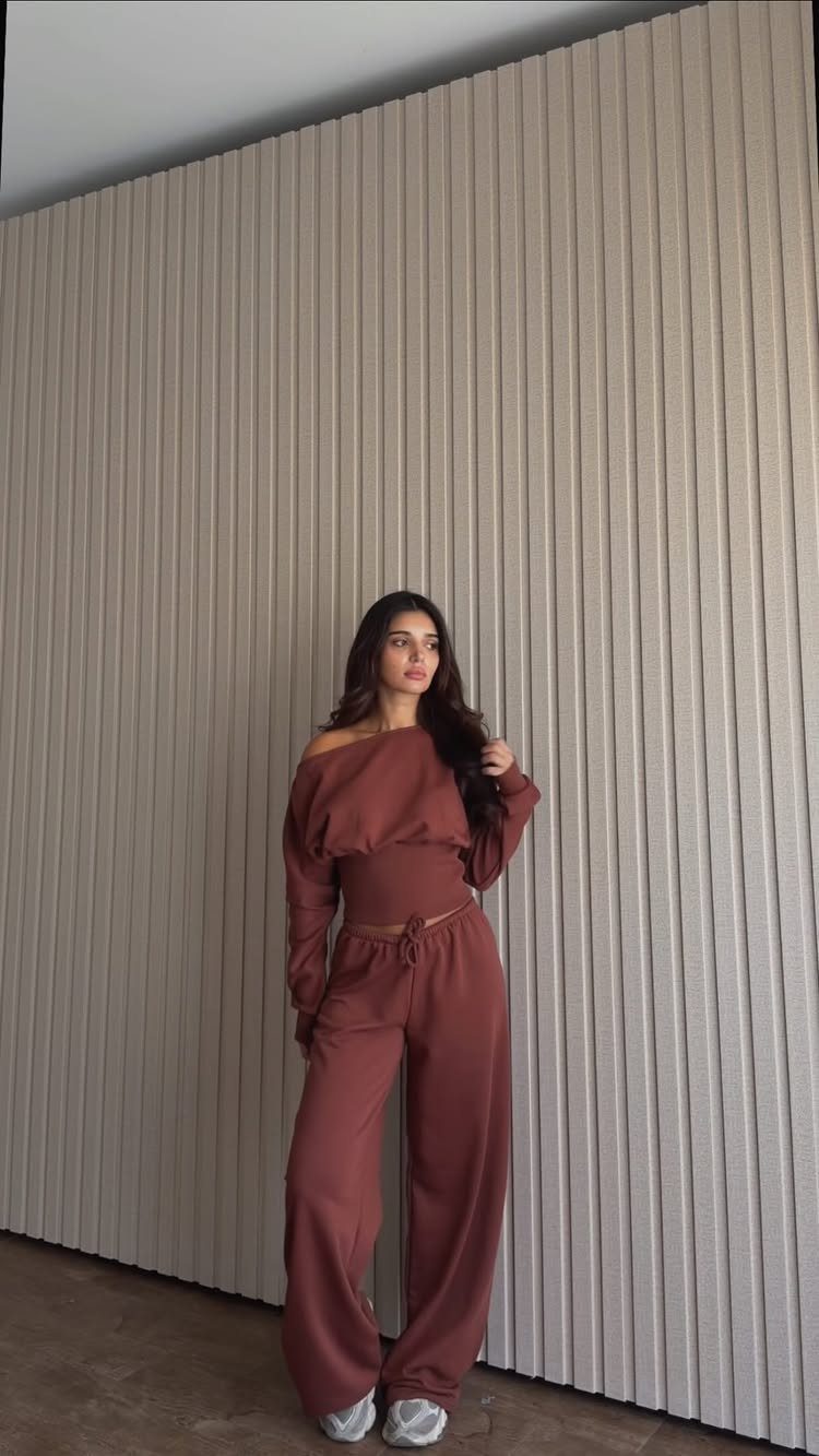 Woman posing in a matching terracotta long-sleeved crop top and wide-leg lounge pants.
