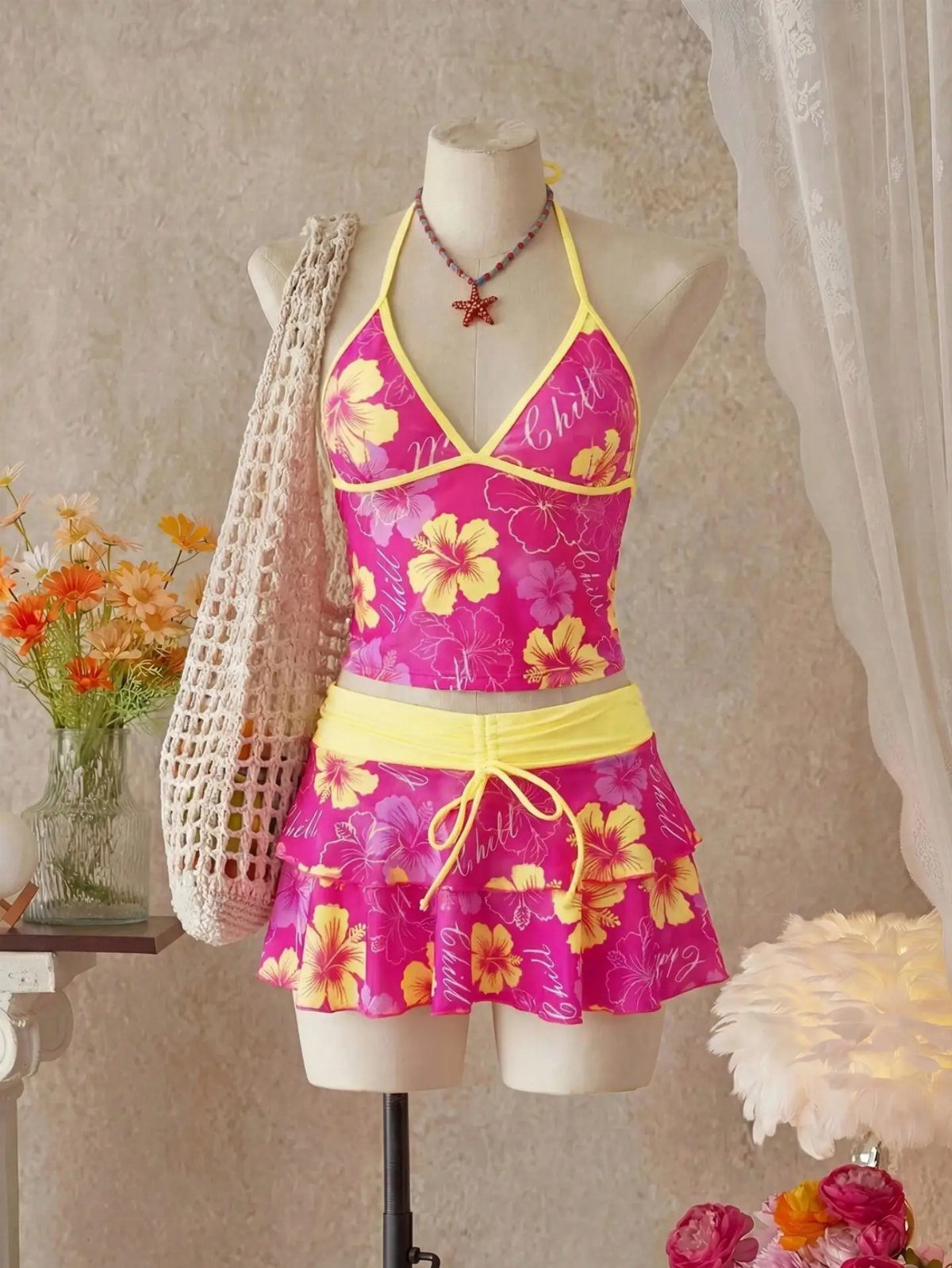 Pink floral hibiscus print halter swimsuit and ruffled skirt on a mannequin.