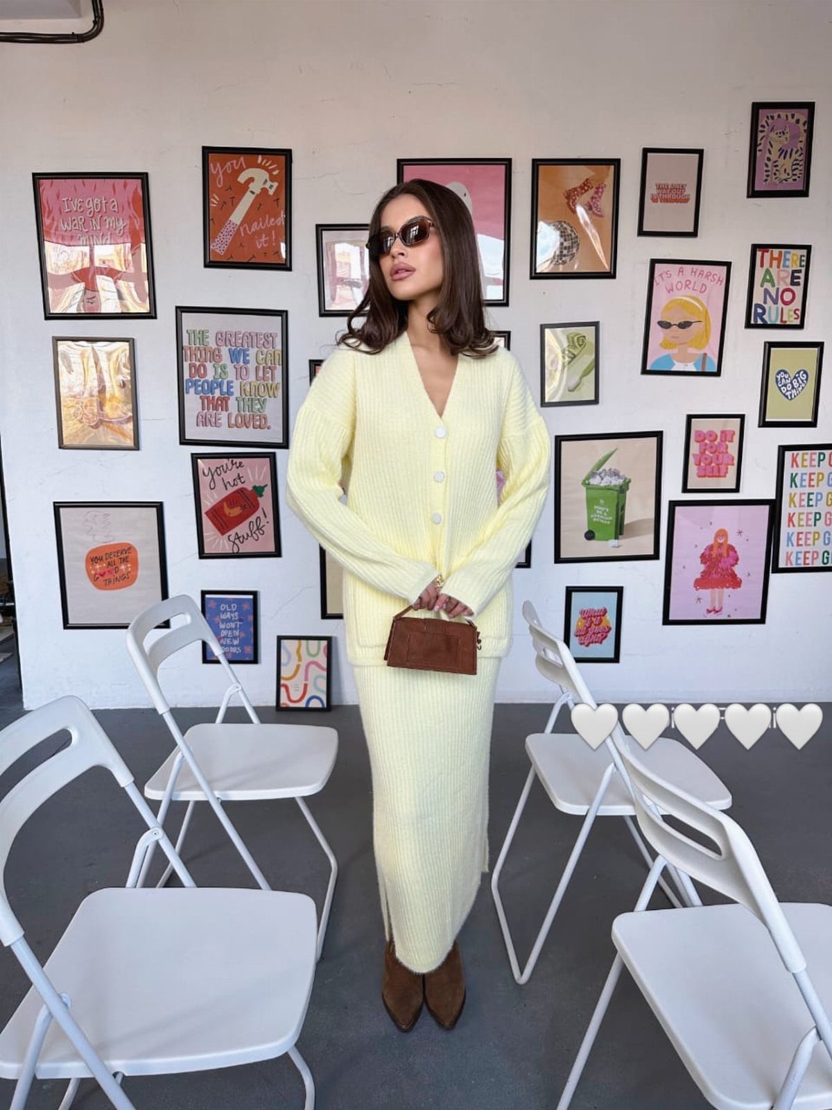 Woman in a yellow knit cardigan and matching skirt wearing brown ankle boots.