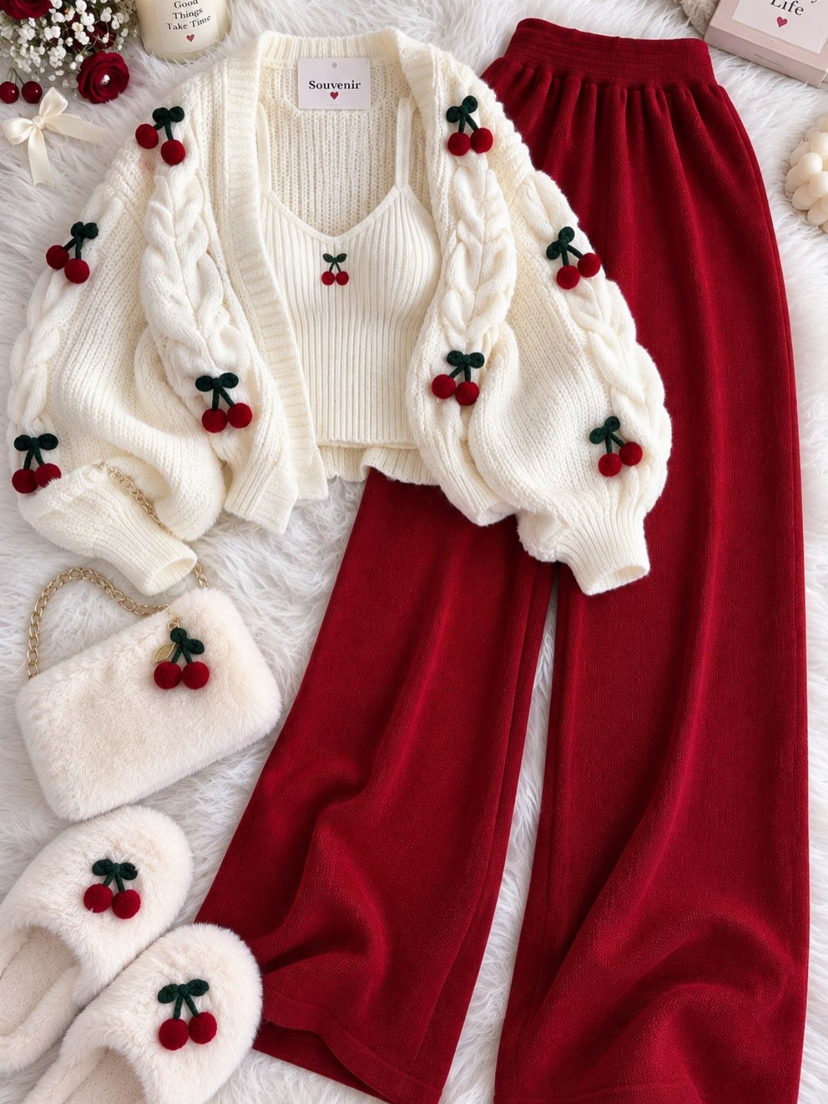 White cherry embroidered cardigan, white tank top, and red wide-leg trousers laid on white fur.