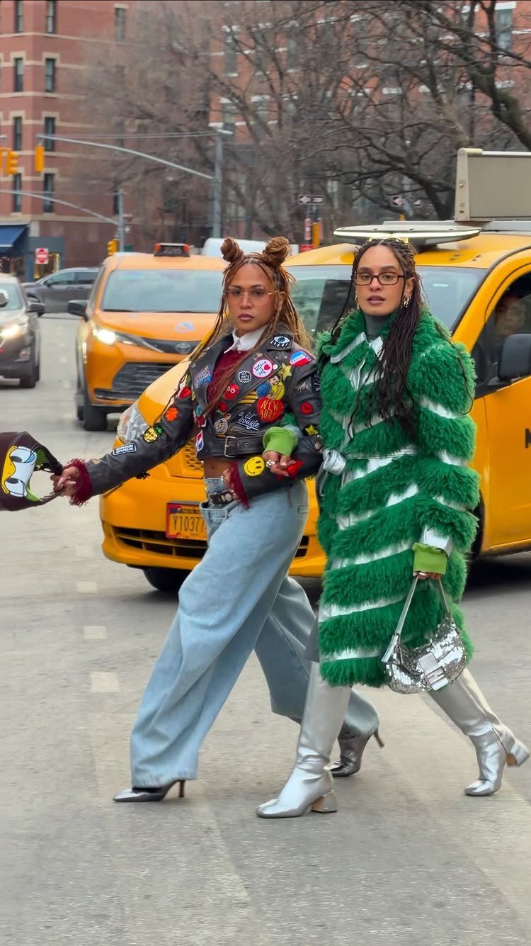 Two women walking through a city street wearing stylish colorful winter clothing and boots.