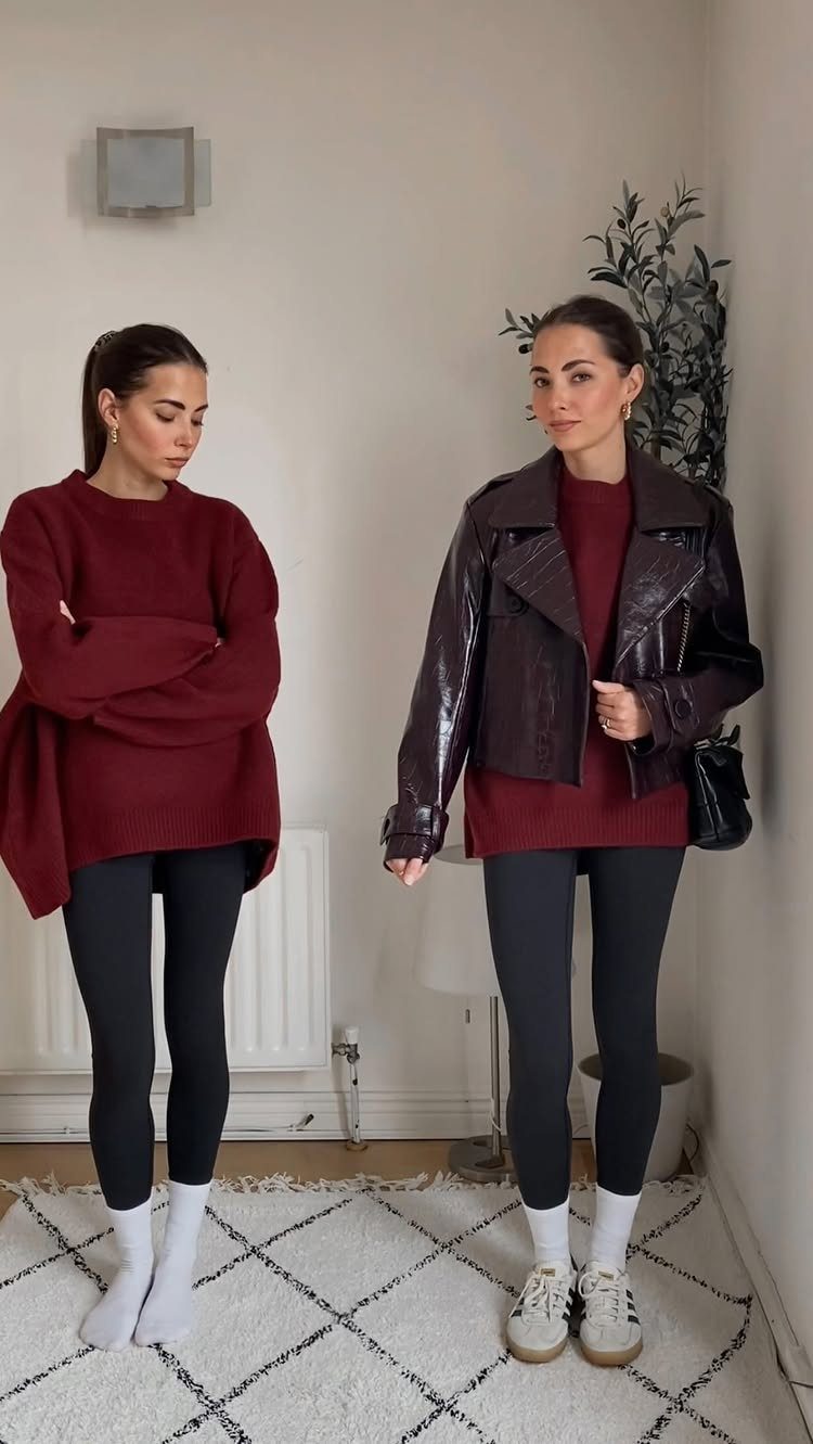 A woman modeling a burgundy sweater paired with black leggings and white socks.