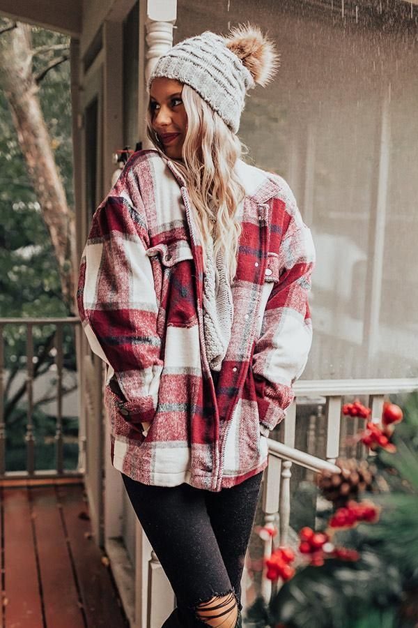 A woman wearing a red and white checkered flannel jacket and a grey beanie.