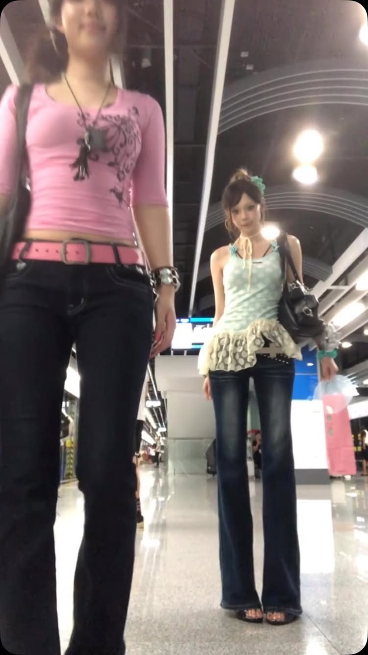 Two young women posing in a hallway wearing iconic early 2000s fashion styles.