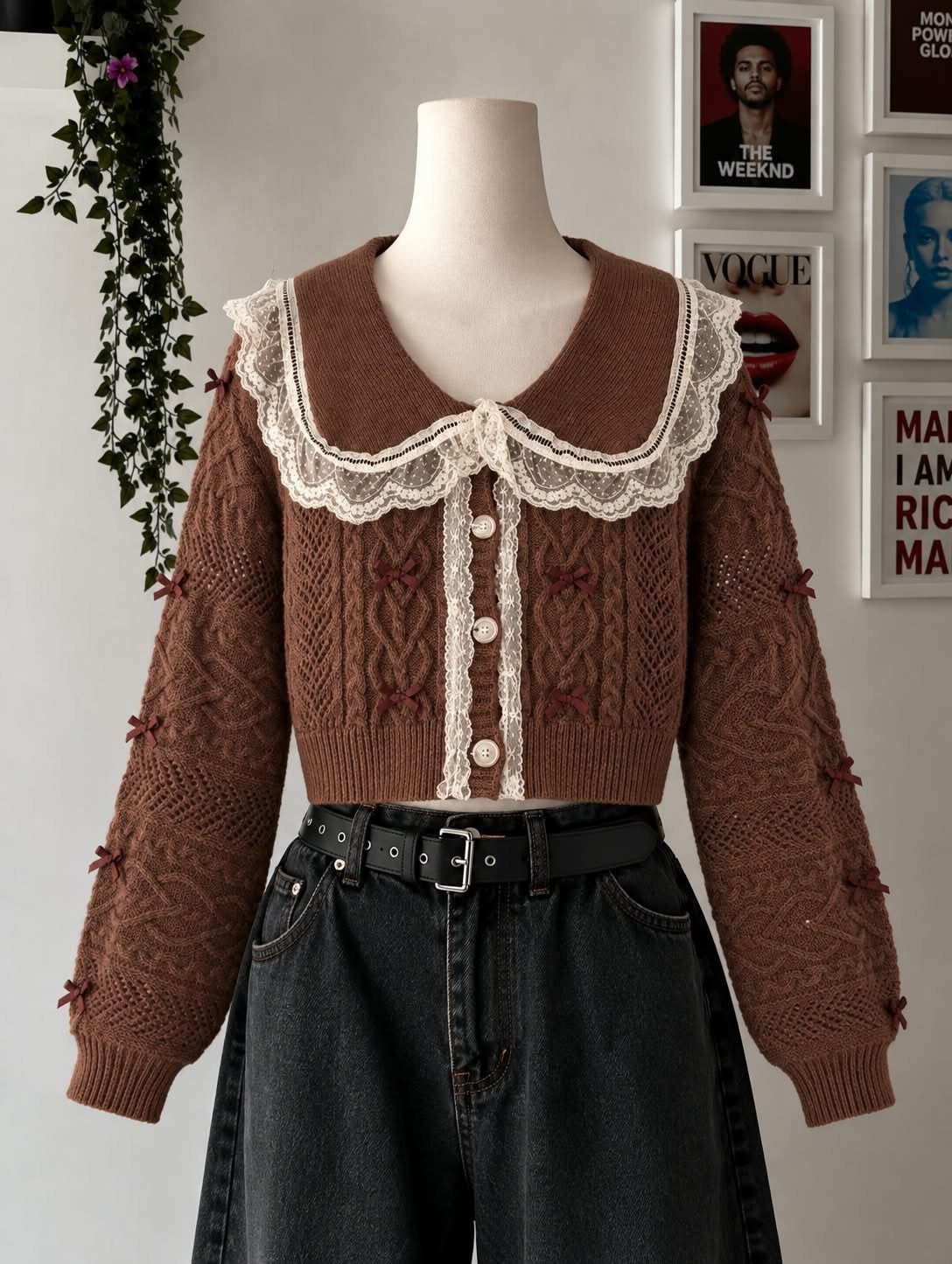 A brown cropped lace cardigan and high waisted black jeans on a mannequin.