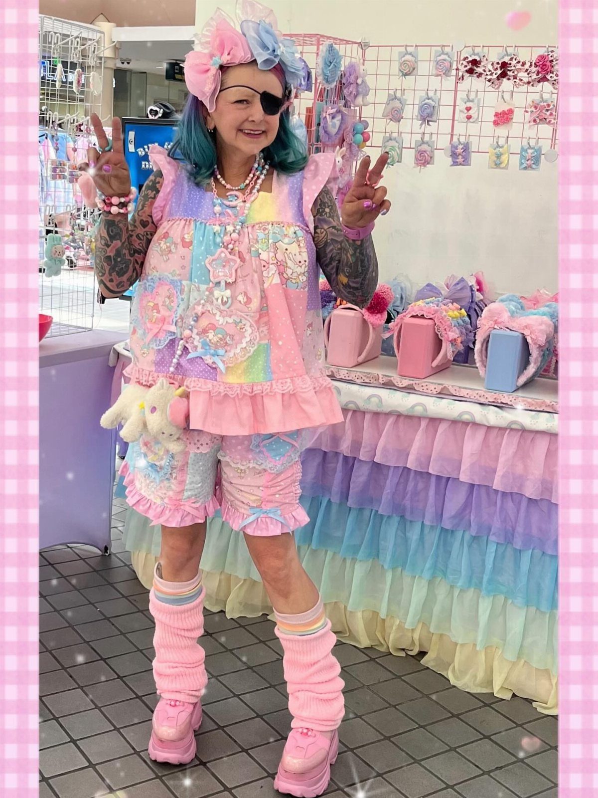 Person in pastel pink ruffled outfit and leg warmers posing in a colorful accessory shop.