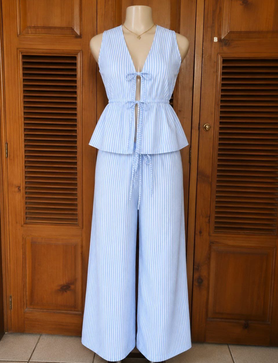 Light blue and white striped seersucker peplum top and wide-leg trousers on a mannequin.