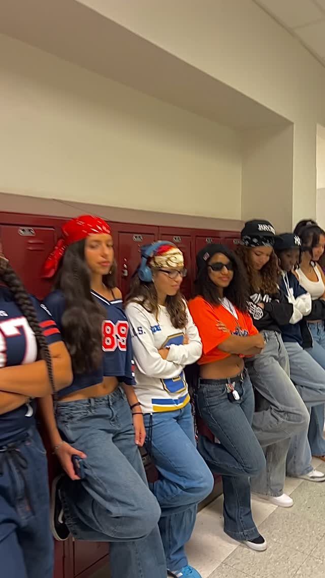 Group of young women posing in a school hallway wearing retro throwback style outfits and bandanas.