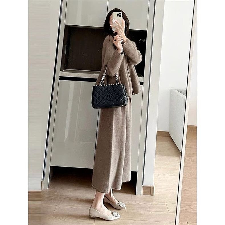 A person wearing a long brown knit sweater dress and matching cardigan with beige flats.
