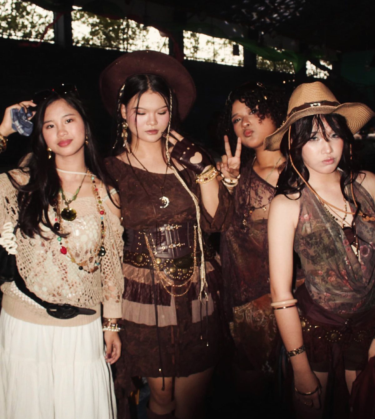 Four women posing in bohemian western outfits with layered jewelry and hats.