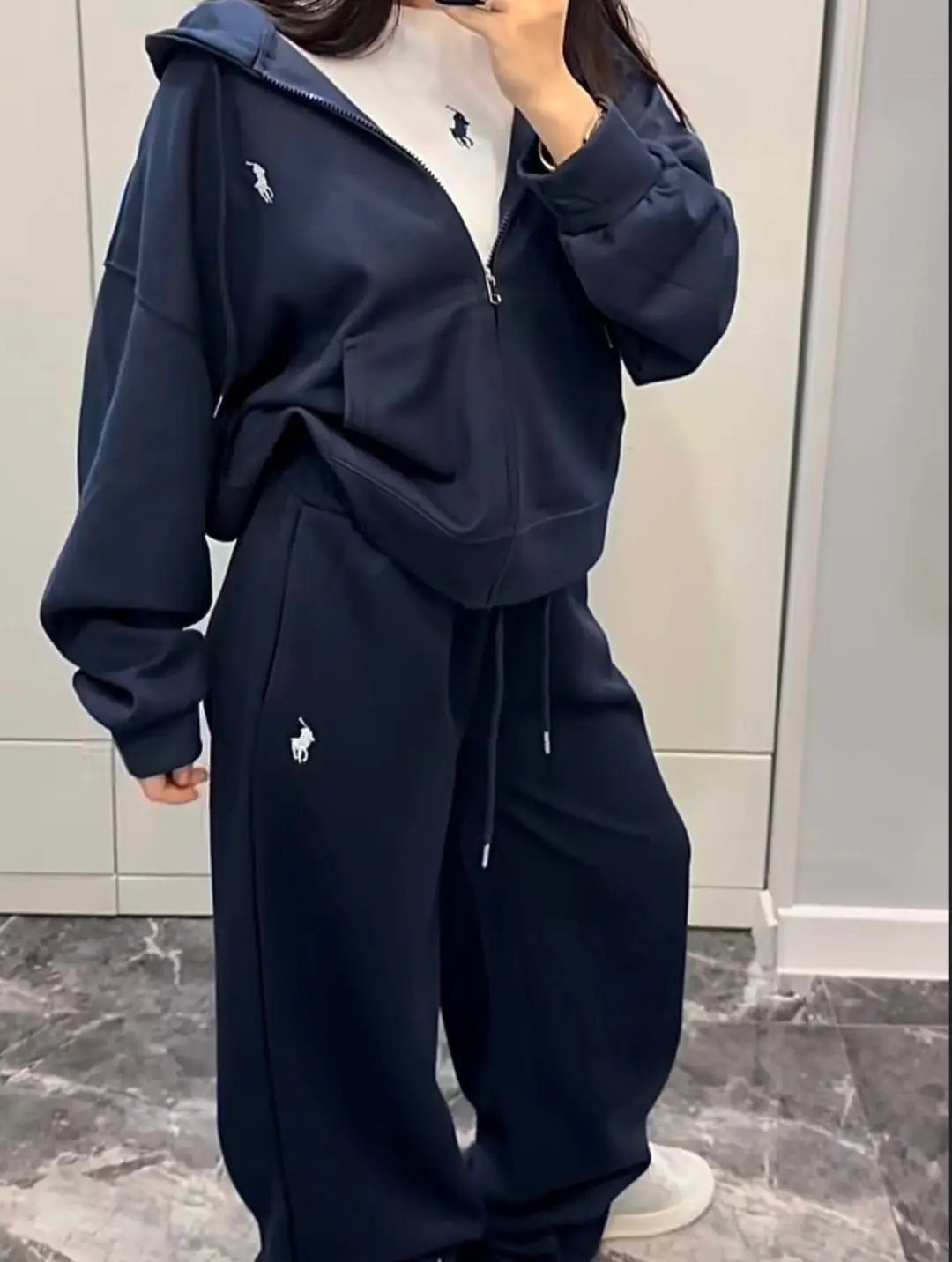 Person wearing a navy blue oversized zip-up hoodie and matching loose sweatpants with white accents.