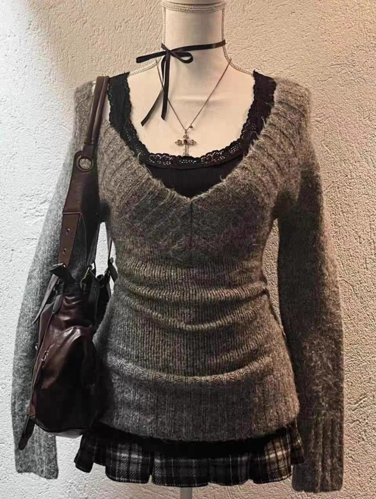Grey off-shoulder knit sweater and plaid mini skirt displayed on a mannequin with accessories.