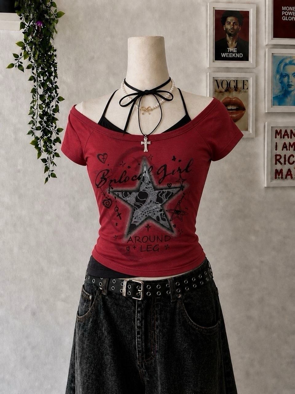 Mannequin wearing a red graphic off-the-shoulder crop top and baggy dark denim jeans.